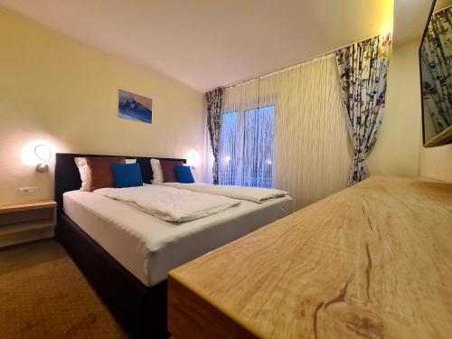 a hotel room with two beds and a window at Beconia Riverside in Văliug