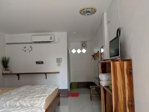 a bedroom with a bed and a flat screen tv at Bansuanphuhong Resort in Chiang Khan
