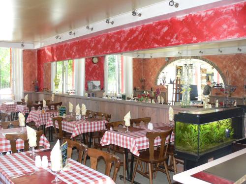un restaurant avec des murs et des tables rouges et un bar dans l'établissement Hotel Le Saint Julien, à Saint-Julien-du-Sault