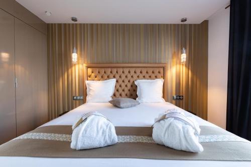 a large white bed with two towels on it at Mercure Bale Mulhouse Aeroport in Blotzheim