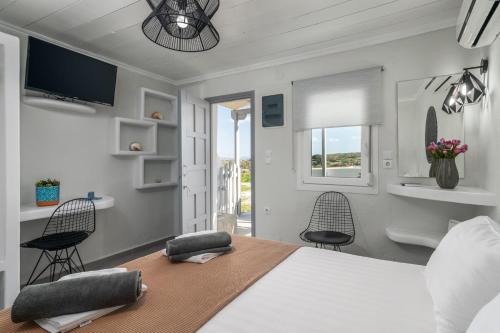 Un dormitorio con una cama grande y dos sillas. en Tsakonas Mandrakia Home, en Mandrakia