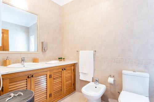 bagno con lavandino, servizi igienici e specchio di Newly refurbished townhouse a Budens