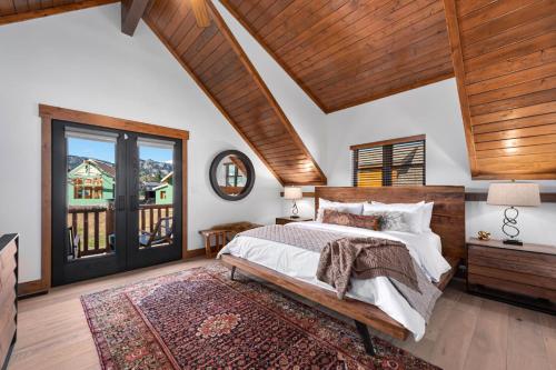 1 dormitorio con 1 cama grande y techo de madera en Relax in The Rockies Located on Lake Estes, Jacuzzi and Indoor Outdoor Fireplace, en Estes Park