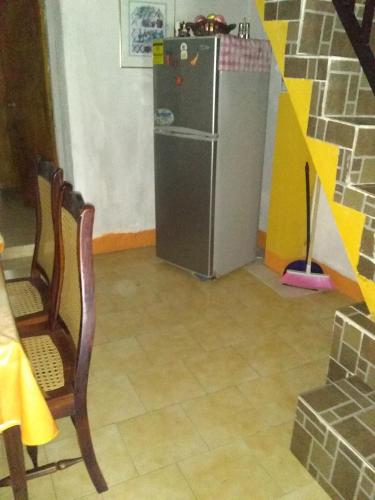 a small refrigerator in a room with a table and a chair at Comfortable inn Green Sea Villa Helen, Kilometro 4 Circunvalar in San Andrés