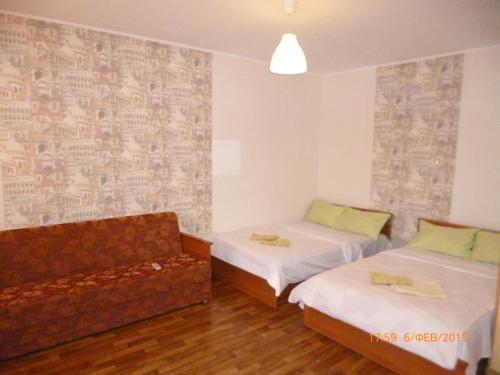 トムスクにあるVictoriaHotel on Musy Dzhalilyaのベッド2台とソファが備わる客室です。
