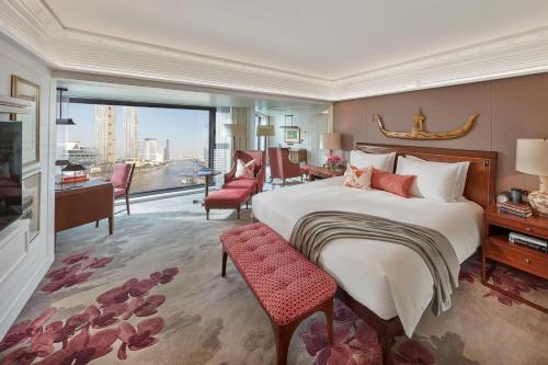 a bedroom with a large bed and a living room at Mandarin Oriental Bangkok - SHA Extra Plus in Bangkok