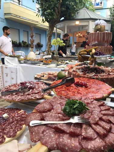 a table filled with lots of different types of meat at Hotel Rosalba - Valentini Family Village in Bellaria-Igea Marina