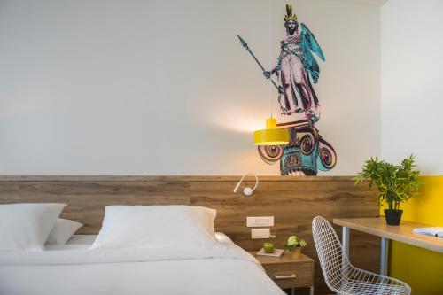a bedroom with a bed and a desk with a lamp at ibis Styles Athens Routes in Athens