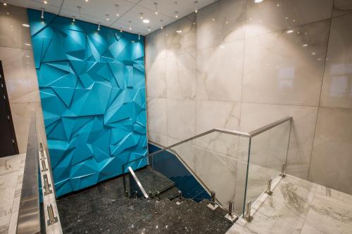 Cette chambre est dotée d'un mur bleu et d'un escalier. dans l'établissement Mirotel Novosibirsk, à Novossibirsk