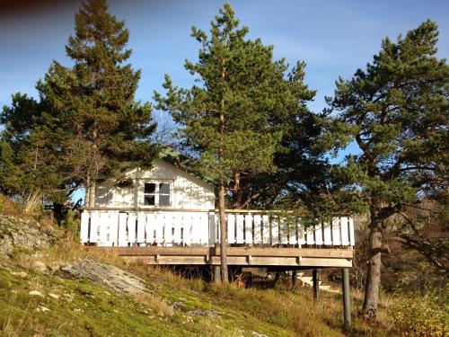 a white house sitting on top of a hill with trees at Kabelvåg Feriehus & Camping in Kabelvåg