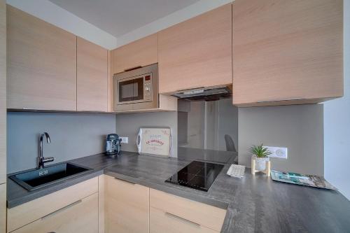 une cuisine avec un évier et un micro-ondes dans l'établissement IMMOGROOM- Magnificent View - NEW - Terrace - AC, à Cannes