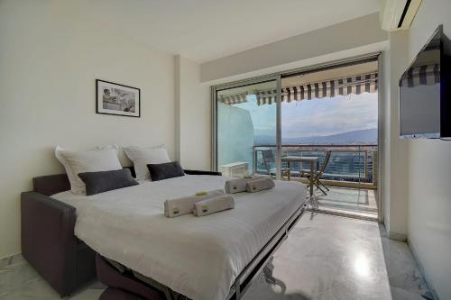 une chambre avec un grand lit avec une grande fenêtre dans l'établissement IMMOGROOM- Magnificent View - NEW - Terrace - AC, à Cannes