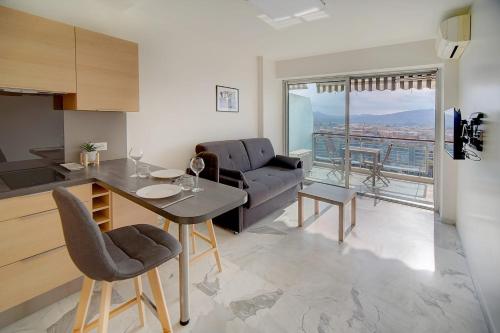 uma cozinha e sala de estar com uma mesa e um sofá em IMMOGROOM- Magnificent View - NEW - Terrace - AC em Cannes