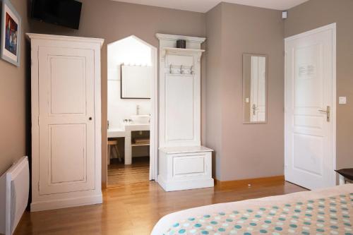 una camera da letto con un letto e un bagno con un lavandino di La Villa Blanche - 18 personnes a Pénestin