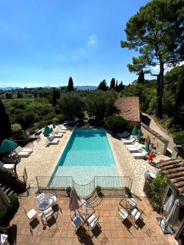 a swimming pool with chairs and a table at Le Manoir de L'Étang in Mougins