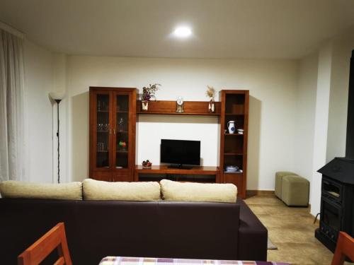 a living room with a couch and a flat screen tv at A Casa de Matelos in A Lanzada