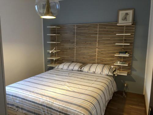 a bedroom with a bed with a large wooden headboard at 034 Splendido Trilocale Pinzolo in Pinzolo