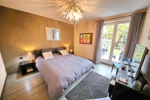 a bedroom with a large bed and a chandelier at Corseaux Beach rooms-Riviera Beach apartments in Vevey