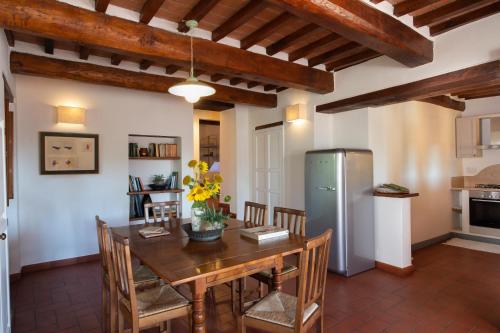 a kitchen and dining room with a table and a refrigerator at La Fattoria del Rio di Sopra - Agriturismo Baldeschi in Tuoro sul Trasimeno