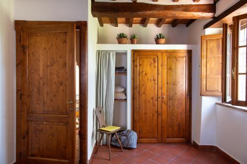 a room with two wooden doors and a chair at La Fattoria del Rio di Sopra - Agriturismo Baldeschi in Tuoro sul Trasimeno