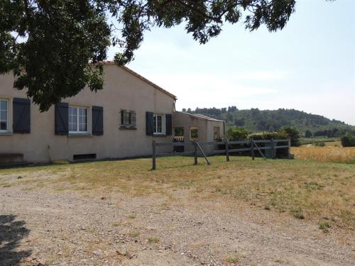 una casa con una valla delante de ella en Le Gîte de la Bade, en Villegailhenc