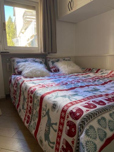 a bed with two dogs laying on top of it at Casa Genepy - monolocale in centro a Sestriere in Sestriere