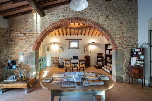 Habitación grande con mesa y pared de piedra. en La Fattoria del Rio di Sopra - Agriturismo Baldeschi, en Tuoro sul Trasimeno