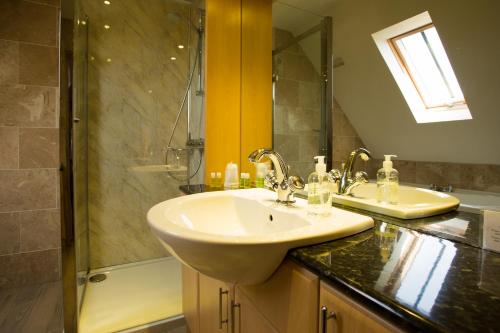 a bathroom with a sink and a shower at The Islay Hotel in Port Ellen