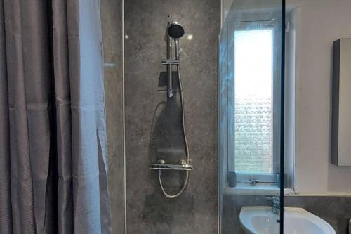 a shower in a bathroom with a sink at Zara Apartments in Dundee