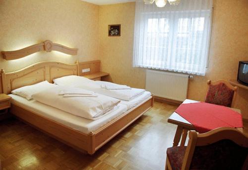 Un pat sau paturi într-o cameră la Adler Gaststube Hotel Biergarten