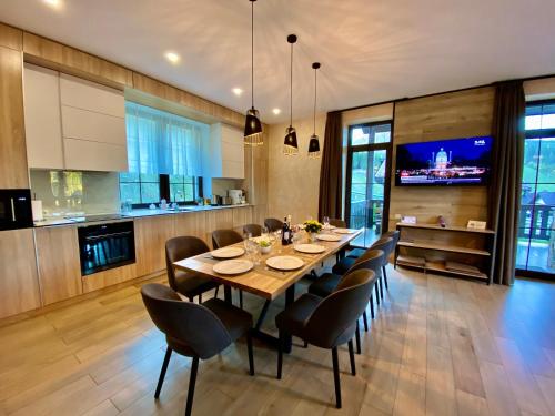 a dining room with a wooden table and chairs at PANORAMA Chalet MOUNTAIN RESIDENCE in Bukovel