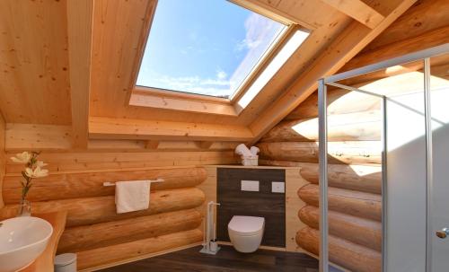 a bathroom in a log cabin with a skylight at Ferienblockhäuser der Familie Lakmann in Feldberg