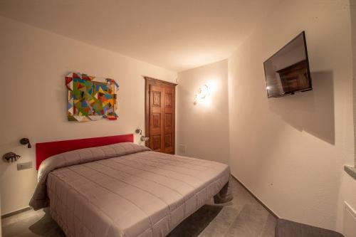 a bedroom with a bed and a tv on the wall at L'Atelier du Temps - Maison Maillet in Aosta