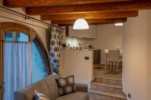 a living room with a couch and a kitchen at L'Atelier du Temps - Les Greniers Appartements in Aosta