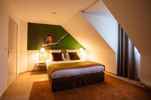 a bedroom with a bed with a bird on a branch at La Maison TATIN in Lamotte-Beuvron