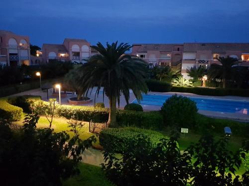 - une vue sur la piscine la nuit dans l'établissement LES SOLEILLADES Parking 200 mètres plage, à Marsillargues