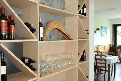 a wine cellar with shelves filled with wine glasses at Logis Hotel Xoko-Goxoa in Saint-Michel