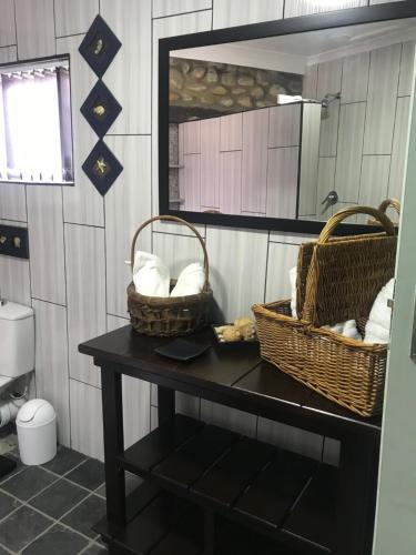 a bathroom with two baskets on a table and a mirror at Whalestone in Port Elizabeth