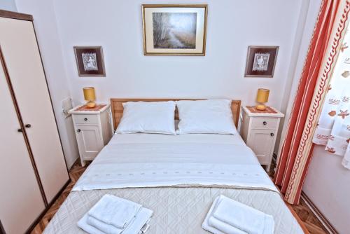 a small bedroom with a bed and two night stands at Apartment Gerber Krk in Krk
