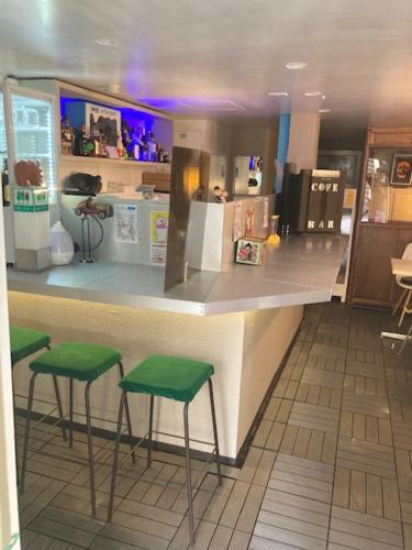 a bar with three green stools at a counter at Asano Hotel in Sapporo
