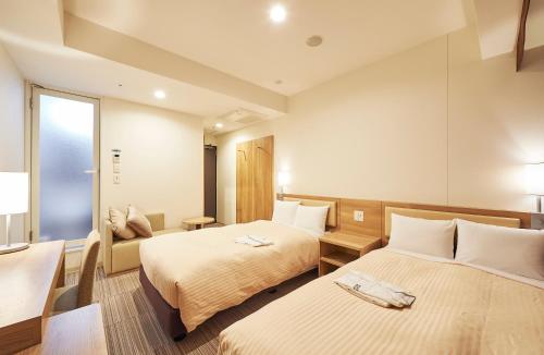 Postel nebo postele na pokoji v ubytování Sotetsu Fresa Inn Kanda-Otemachi