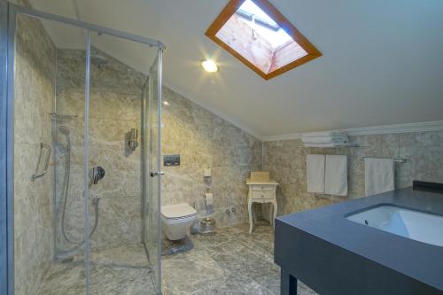 uma casa de banho com um chuveiro, um WC e um lavatório. em My Marina Select Hotel em Datça