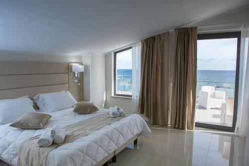 a bedroom with a large bed with a view of the ocean at Hotel Dolce Stella in Torre Melissa