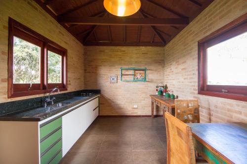 a kitchen with a sink and a table in a room at Magnificat Cottage in Cunha