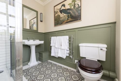 a bathroom with a toilet and a sink at The Courtyard House in Dorchester