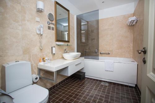 a bathroom with a sink and a tub and a toilet at Vihula Manor Country Club & Spa in Vihula