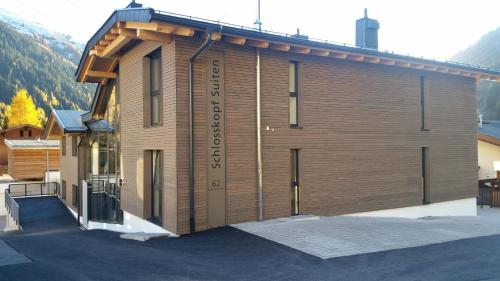 a large wooden building with a sign on it at Schlosskopf Suiten in Sankt Anton am Arlberg