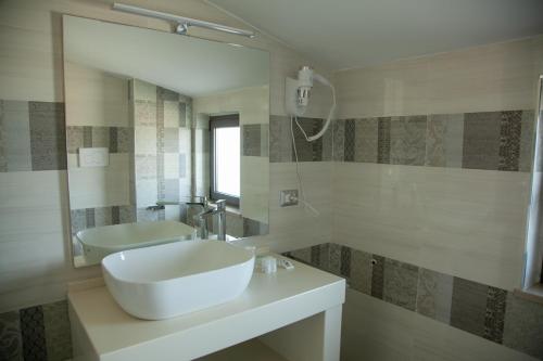 a white bathroom with a sink and a mirror at Hotel Dolce Stella in Torre Melissa