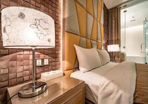 sypialnia z łóżkiem i lampką na biurku w obiekcie Eusta Motel w mieście Taizhong