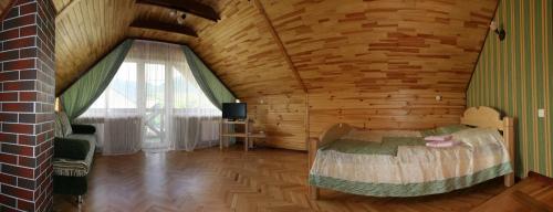 een slaapkamer met een bed in een houten kamer bij Гніздо Беркута in Tukhlya
